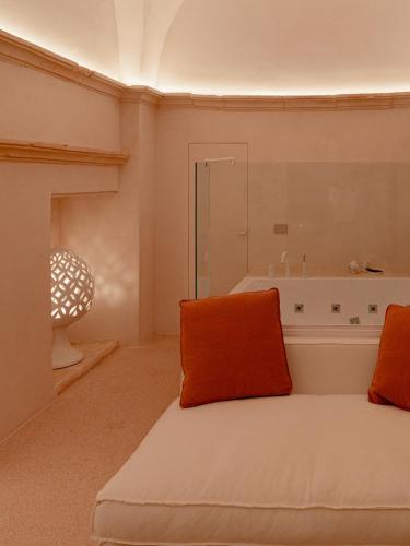 a room with a bed with an orange pillow on it at Masseria Eirene in Lecce