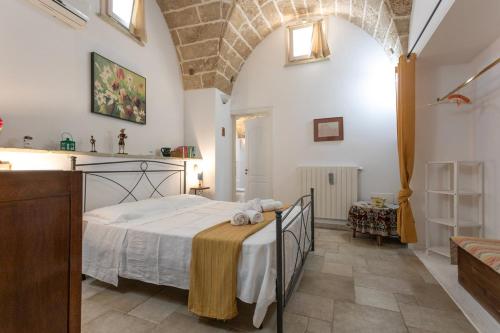 a bedroom with a large bed in a room with a kitchen at Giardino dellorologio - Salento Reservation in Racale