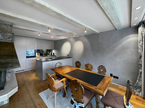 eine Küche und ein Esszimmer mit Tisch und Stühlen in der Unterkunft Herrliche 3 Schlafzimmer Wohnung in Davos zentral & exklusiv in Davos