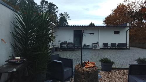 a backyard with a white building with a table and chairs at Alojamento 444 in Monção