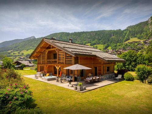 eine Blockhütte mit Tisch und Stühlen im Hof in der Unterkunft Chalet Ibusta - OVO Network in Le Grand-Bornand