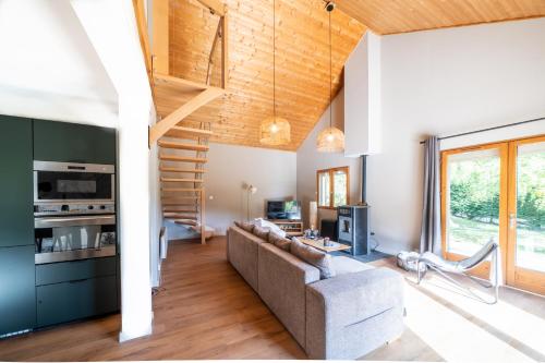 een woonkamer met een bank en een trap bij Chalet Le cocon plein sud in Saint-Chaffrey