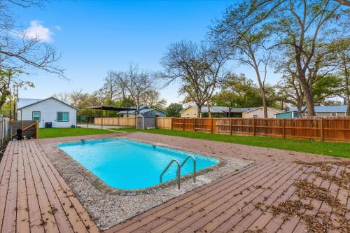 een zwembad in een tuin met een houten hek bij Modern NB Getaway with Pool in New Braunfels