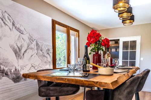 een eetkamer met een houten tafel en stoelen bij Chalet Le cocon plein sud in Saint-Chaffrey