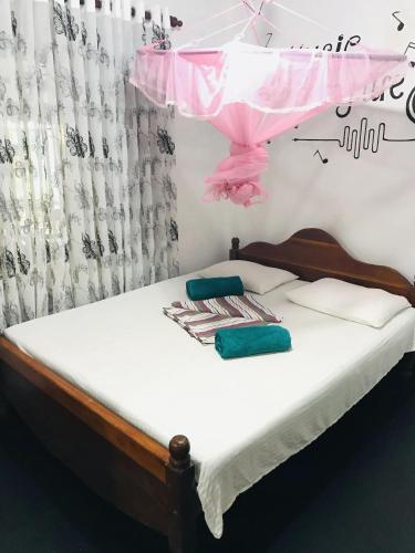 a bedroom with a bed with a pink canopy at Mihira Guest House in Ahangama