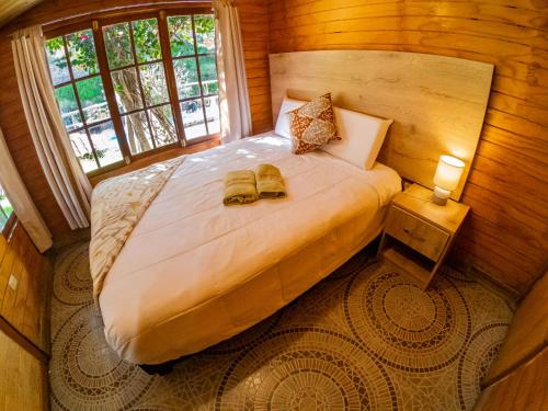a bedroom with a bed with two slippers on it at Kay Pacha Wellness Place Eco in Ayacucho