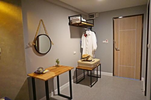 a bathroom with a mirror and a table and a sink at Hansa Bangkok House in Bangkok