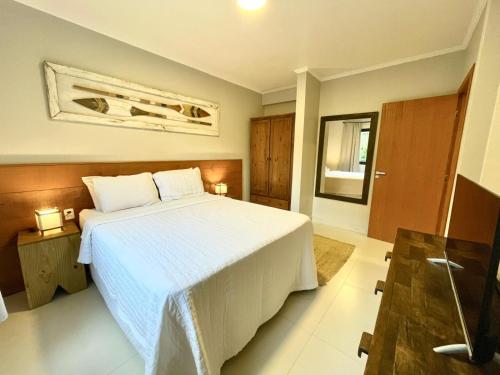 ein Schlafzimmer mit einem großen weißen Bett in einem Zimmer in der Unterkunft Casa Mar Villas in Florianópolis
