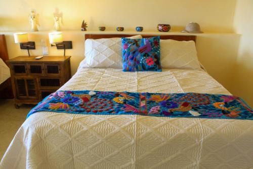 a bed with a quilt on it in a bedroom at Casa Bul-Kay's - Where Confort Meets Consierge Care in Chicxulub