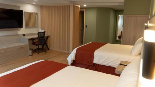 a hotel room with two beds and a desk at Econo Express Metepec in Toluca