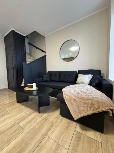 La suite Nova - Jacuzzi في فالنسيان: غرفة معيشة مع أريكة سوداء وطاولة
