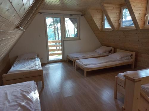 Ένα ή περισσότερα κρεβάτια σε δωμάτιο στο Domek Pod Sosnami