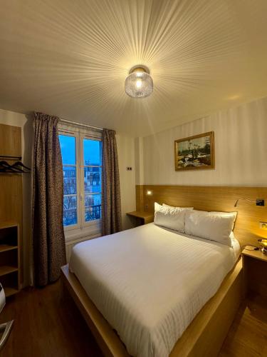 a bedroom with a large bed and a window at Hôtel Montmartre - Nouvellement Rénové in Paris