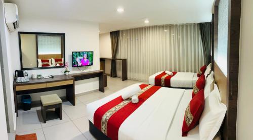 a hotel room with two beds and a television at Elite Hotel KL Sentral in Kuala Lumpur