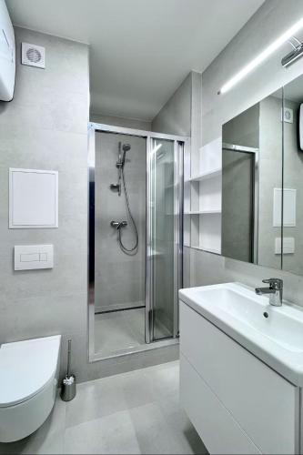 a bathroom with a shower and a toilet and a sink at Lumen apartmán in Komárno