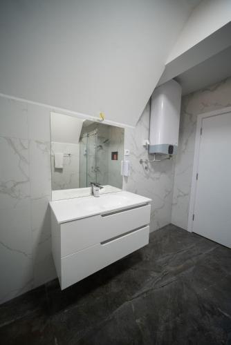 a white bathroom with a sink and a mirror at Ilic House in Belgrade