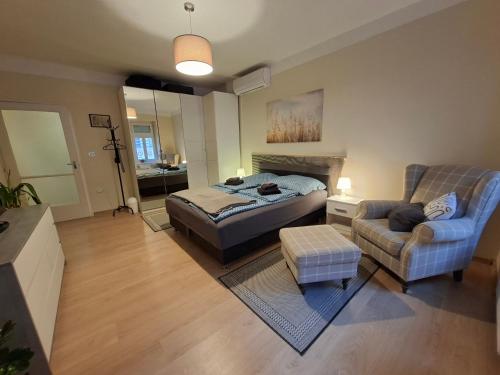 una camera da letto con un letto, un divano e una sedia di Vince apartman a Pécs