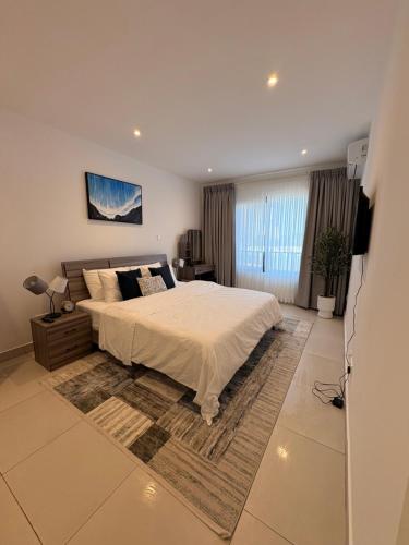 a bedroom with a bed and a television in it at Signature 1 Bedroom at The Bantree Accra in Accra