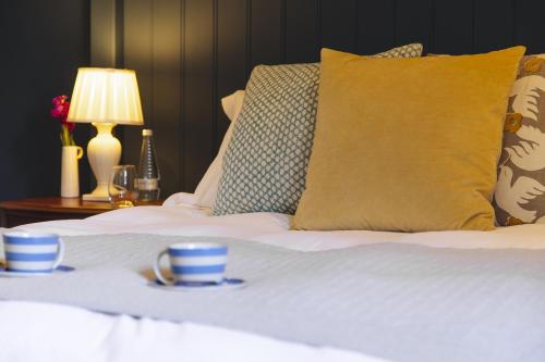 a bed with two blue and white cups on it at The Blue Ball Inn in Sidmouth