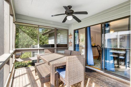 a porch with a table and chairs and a ceiling fan at Oceanwoods 452 in Kiawah Island