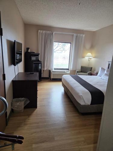 a hotel room with a bed and a window at McPherson Inn in McPherson