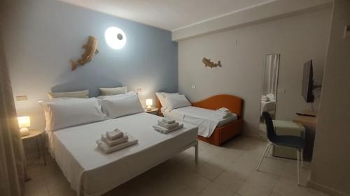 ein Schlafzimmer mit zwei Betten und einem Schreibtisch und einem Stuhl in der Unterkunft Hotel Sole in Orbetello