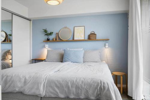 a bedroom with a large bed with a blue wall at 1900-Romo-Klitrosevej-40 in Sønderby