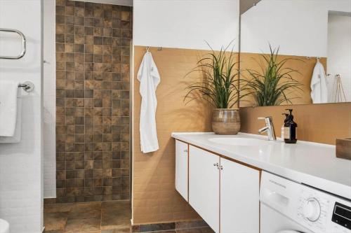 a bathroom with a white sink and a shower at 1900-Romo-Klitrosevej-40 in Sønderby