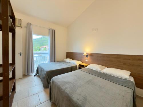 Giường trong phòng chung tại Juquehy Studios 8 e 10