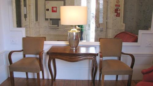 
a wooden table topped with a lamp next to a window at Koolhouse Porto in Porto
