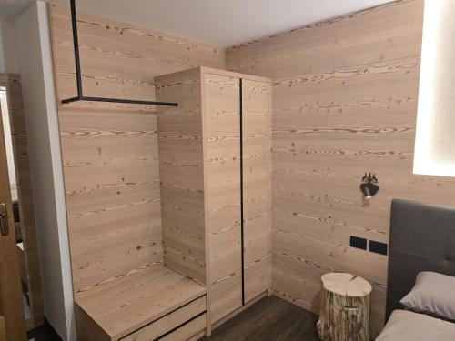 a shower in a room with wooden walls at Appartamento Rita in Pozza di Fassa