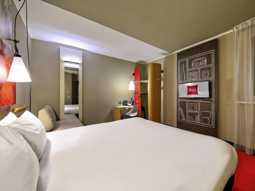 un grande letto bianco in una stanza d'albergo di Ibis Gdansk Stare Miasto a Danzica