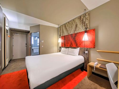 a bedroom with a white bed and a red rug at Ibis Gdansk Stare Miasto in Gdańsk