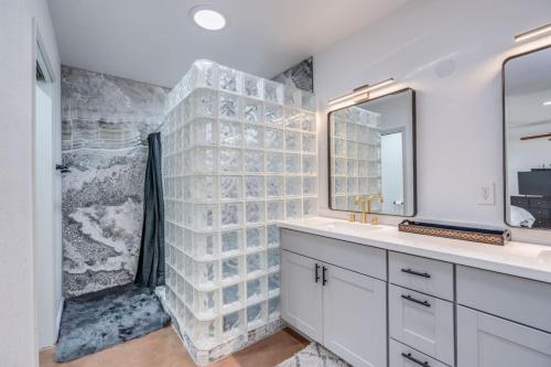 a bathroom with a shower and a sink and a mirror at Parkway Terrace in Tucson