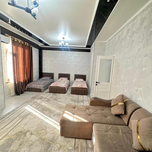 ein Wohnzimmer mit zwei Betten und einer Couch in der Unterkunft КАРАВАН САРАЙ 15 Венеция in Türkistan