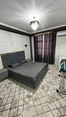 ein Schlafzimmer mit einem großen Bett und einem Kronleuchter in der Unterkunft КАРАВАН САРАЙ 15 Венеция in Türkistan