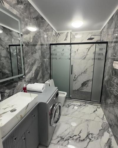 a bathroom with a shower and a sink and a toilet at КАРАВАН САРАЙ 15 Венеция in Türkistan