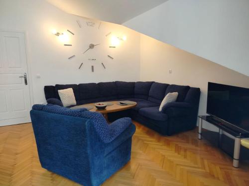 a living room with a couch and a clock on the wall at Udoban dvosoban stan 450 metara od mora in Boreti