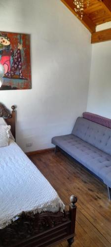 a bedroom with a bed and a bench in a room at El ceibo in Agua de Oro