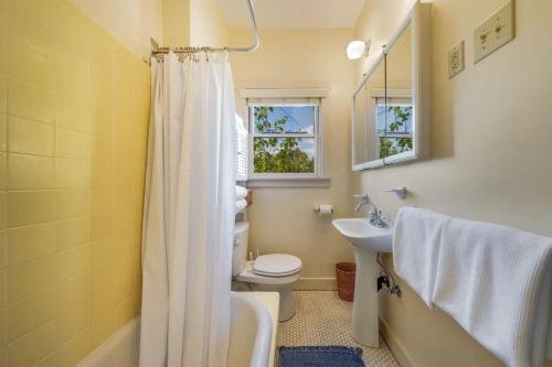 a bathroom with a white shower curtain and a sink at Casita #7 in Tucson