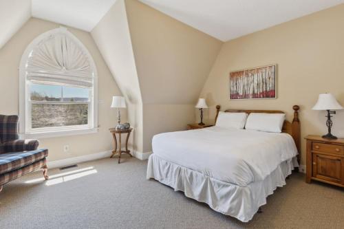 a bedroom with a large white bed and a window at 225 Snowbridge with Village Shuttle in Collingwood