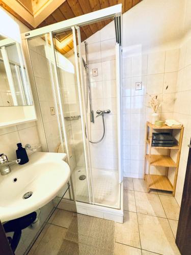 a bathroom with a shower and a sink at Bergtraum Suite in Kandersteg