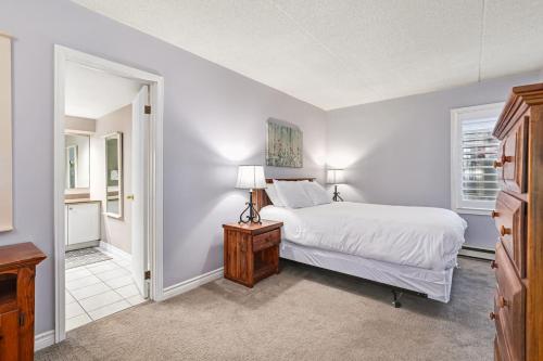 a white bedroom with a bed and a window at 2BDR Condo Steps to Blue Mountain Village - 101 Cachet Crossing in Blue Mountains