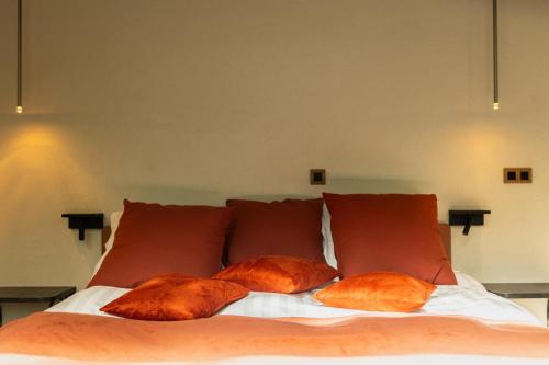 a bed with three brown pillows on it at Hortensia 7 in La-Roche-en-Ardenne