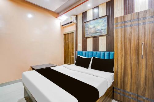 a bedroom with a large bed with a wooden wall at Hotel O Rameshwar Inn in Prayagraj