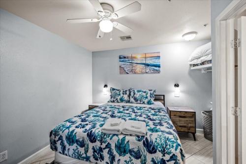 a bedroom with a bed and a ceiling fan at Seashell Retreat - Beachfront Condo with Pools and Cabanas in Galveston