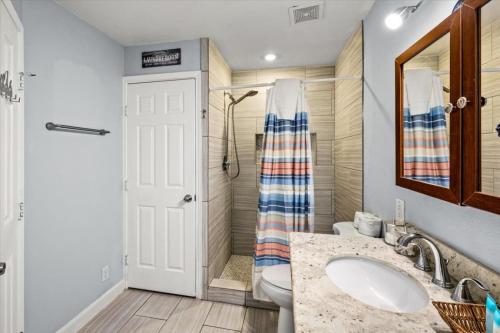 a bathroom with a sink and a shower at Seashell Retreat - Beachfront Condo with Pools and Cabanas in Galveston