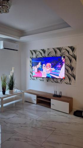 Una sala de estar con un televisor de pantalla plana en una pared. en Apartament Luxury, en Bucarest