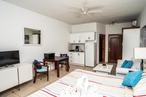 ein Wohnzimmer mit einer Couch, einem Tisch und einer Küche in der Unterkunft Agualina Kite Hotel in Cabarete