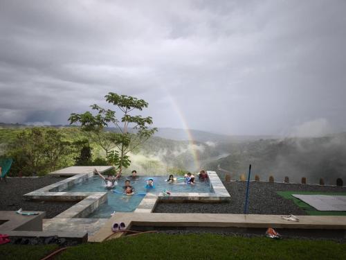 a group of people in a swimming pool with a rainbow at Rancho Alto Túcan in Buenos Aires